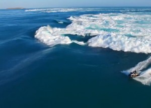 Nebojácný muž na vodním skútru závodí s přílivovou vlnou