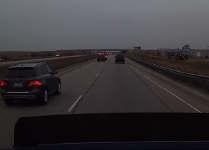 Muž se lepí na záda auta před sebou - pak se druhý řidič rozhodne, že už má dost